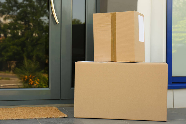 Cardboard boxes near door. Parcel delivery service - Foto, imagen