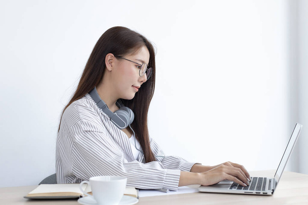 Aziatische vrouw studeert online via haar laptop in haar huis, thuisblijven, Nieuw normaal, Covid-19 coronavirus, Sociale afstand, Internet leren. - Foto, afbeelding
