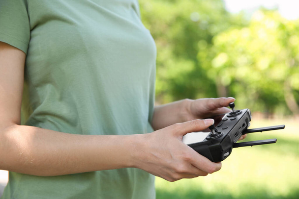 Woman holding new modern drone controller outdoors, closeup of hands - Foto, Imagem