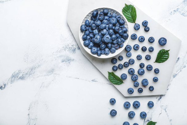 Tasty blueberry in bowl on light background - 写真・画像