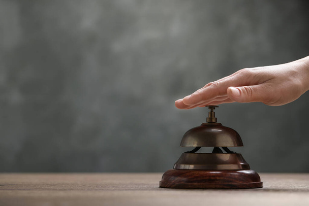 Man ringing hotel service bell at table, closeup. Space for text - Foto, Bild