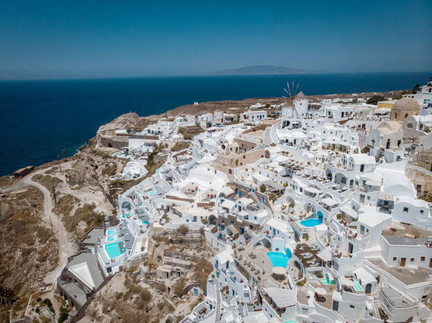 Drone view over Santorini, aerial view over the whitewashed village of Oia with luxury vacation resort with infinity pools in Santorini Greece - Photo, Image