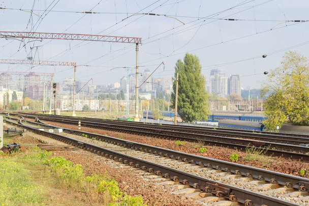 Σύγχρονοι σιδηρόδρομοι πολλαπλών γραμμών με σιδηροδρομικούς διακόπτες και άλλες μηχανολογικές κατασκευές σε φόντο αστικής δομής - Φωτογραφία, εικόνα
