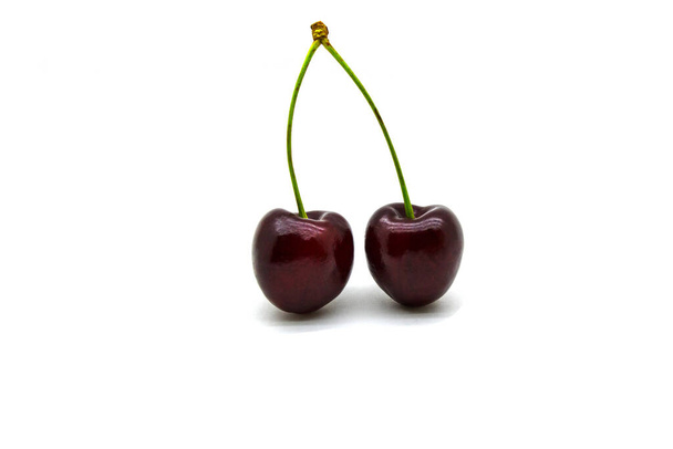 Two ripe cherries on a twig close up on a white background - Fotó, kép