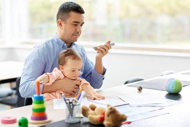 father with baby and phone working at home office - Foto, immagini