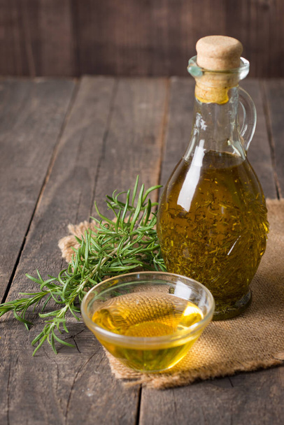 Rosemary oil on wooden background. Natural food concept.  - Foto, Imagem