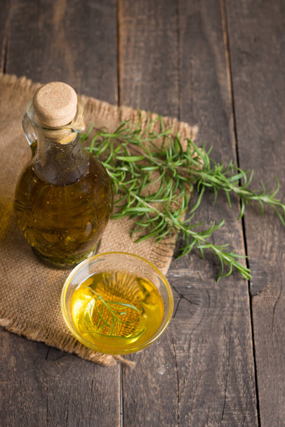 Rosemary oil on wooden background. Natural food concept.  - Zdjęcie, obraz