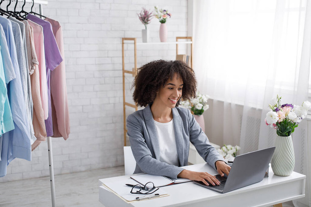 Trabajar en casa durante la cuarentena covid-19. Mujer afroamericana feliz escribiendo en el ordenador portátil - Foto, imagen