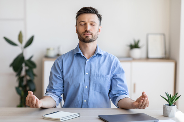 Офіс Дзен. Розслаблений чоловік підприємець медитує на робочому місці, впорається зі стресом роботи
 - Фото, зображення