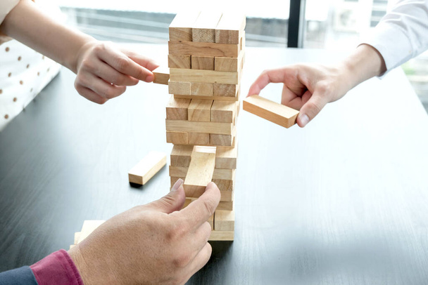 Three hands playing blocks wood game, gambling placing wooden block. Concept Risk of management and strategy plan, growth business success process, and teamwork. - Fotoğraf, Görsel