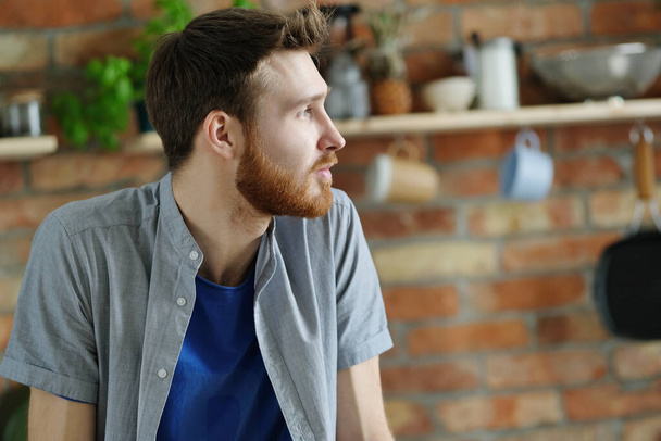 Handsome young man with beard posing on the kitchen - Foto, afbeelding