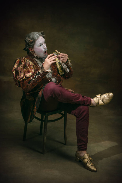 Young man as Johann Sebastian Bach on dark green background. Retro style, comparison of eras concept. - Foto, imagen