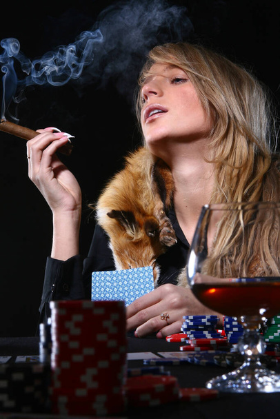 Красивая сексуальная женщина играет в покер и курит сигары - Фото, изображение