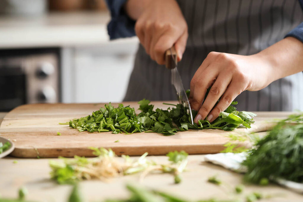 Koken. Chef snijdt groen in de keuken - Foto, afbeelding