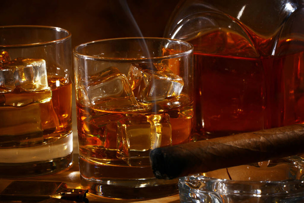 Koude whisky en sigaar tegen oude achtergrond - Foto, afbeelding