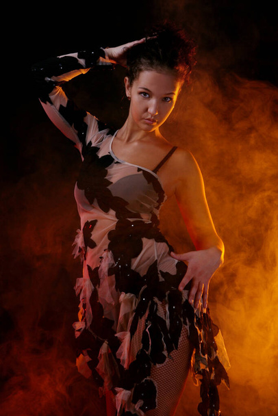 bela mulher dançando salsa dança no fundo de fumaça laranja - Foto, Imagem