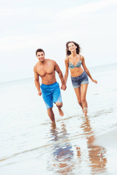  Hermosa y atractiva pareja realxing en la playa del mar - Foto, imagen