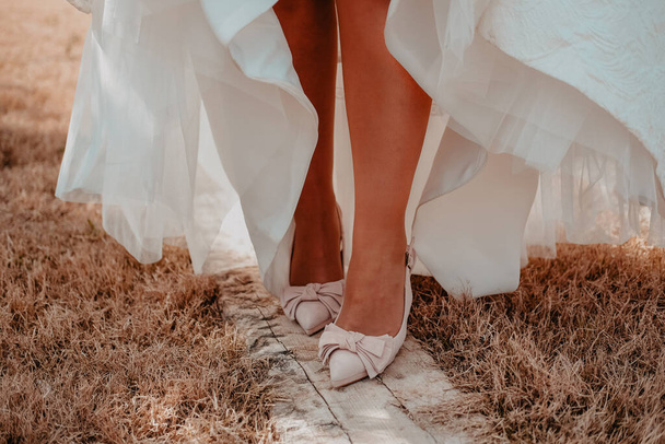 Η σύζυγος δείχνει τα όμορφα και άσπρα παπούτσια της. - Φωτογραφία, εικόνα