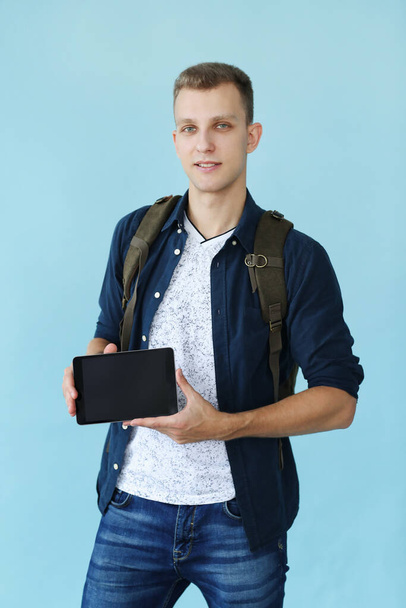 Handsome man with tablet on a blue background - Фото, зображення