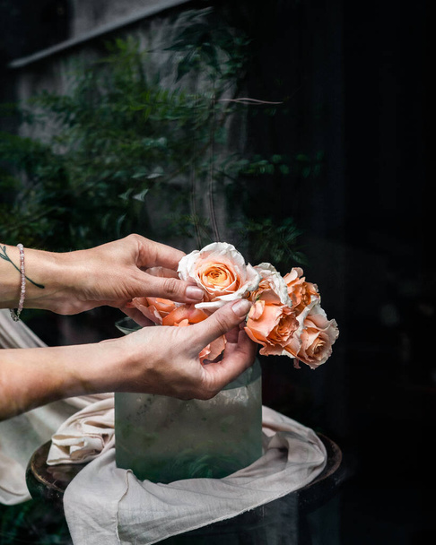 Bright  roses in vase and hands - Φωτογραφία, εικόνα
