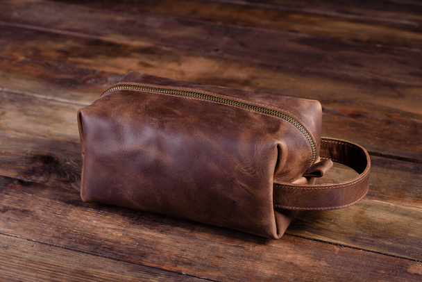 Old vintage leather bag with leather strap. Beautiful small women's leather bag on a wooden background - Photo, Image