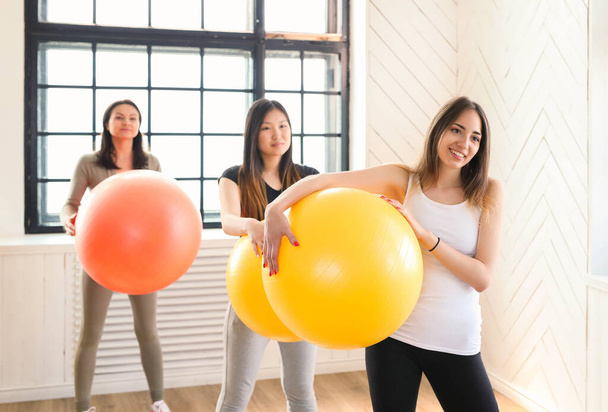 Młode kobiety ćwiczą z piłkami na siłowni - Zdjęcie, obraz