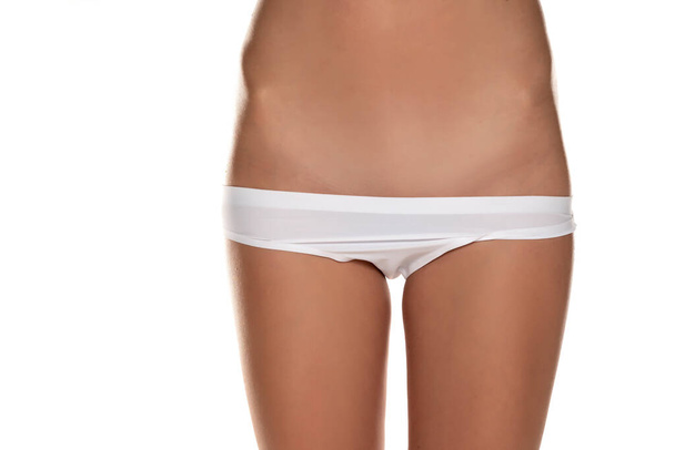 mulher com calcinha para baixo mostra sua área pubiana raspada no fundo branco - Foto, Imagem