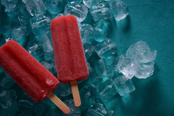 Strawberry popsicle on blue background - Foto, afbeelding