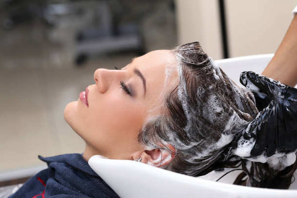 Salon fryzjerski. Kobieta podczas mycia włosów - Zdjęcie, obraz