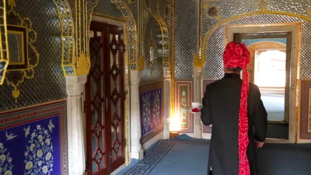 Indie, Rajasthan, Jaipur, Samode Palace, číšník nesoucí čaj podnos ve zdobené chodbě - Model a majetek propuštěn - Záběry, video