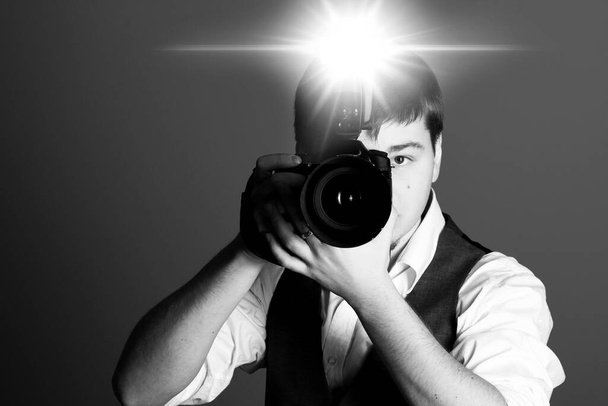 Fotógrafo con cámara en estudio - Foto, imagen