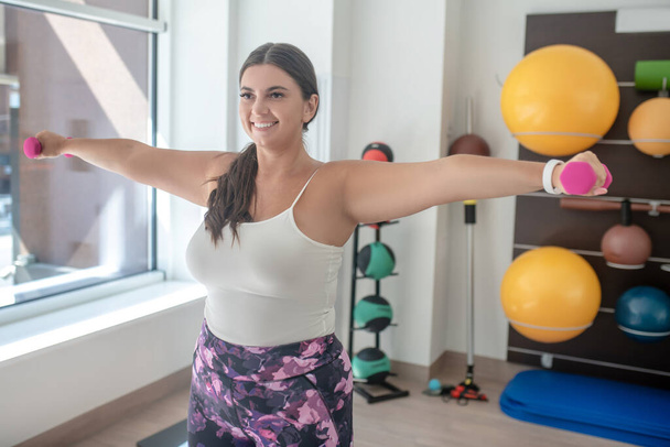 Femme faisant des exercices avec haltères dans la salle de gym - Photo, image