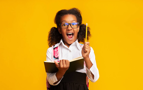 Aufgeregt Schwarzes Schulmädchen hält Bleistift mit Idee im Stehen, Studioaufnahme - Foto, Bild