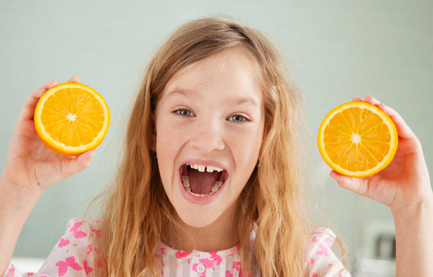 Cheerful girl with orange - Fotoğraf, Görsel