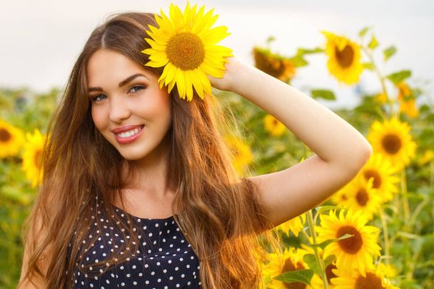 Cute girl in the field full of sunflowers - Photo, Image