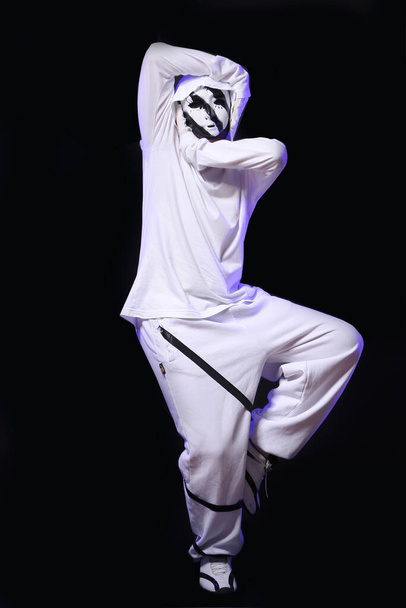 スタジオで踊る白い衣装を着たスタイリッシュなヒップホップダンサー - 写真・画像