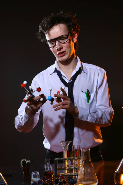 Beyaz gömlekli genç kimyager laboratuarda deney yapıyor. - Fotoğraf, Görsel