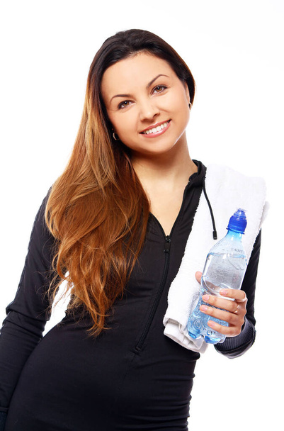 Beautiful smiling woman with  bottle of water and towel isolated over white - Fotó, kép