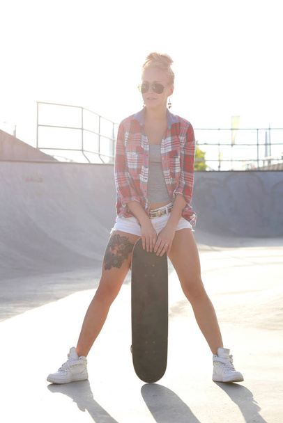 Young woman skateboarding in the skate park - Zdjęcie, obraz