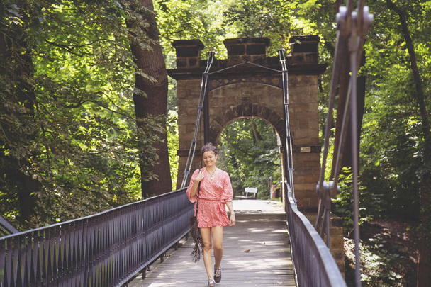 Woman in red dress walking on the bridge, Decin castle in Bohemia - Zdjęcie, obraz