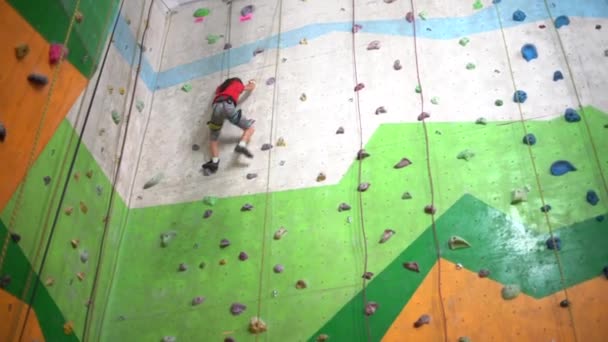 Egy kislány mászik fel a falra egy sziklás tornateremben. - Felvétel, videó