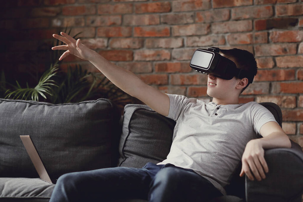 Хлопчик-підліток використовує гарнітуру віртуальної реальності
 - Фото, зображення