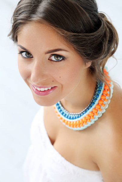Portrait of young beautiful woman with beaded necklace on white background - Foto, Imagem