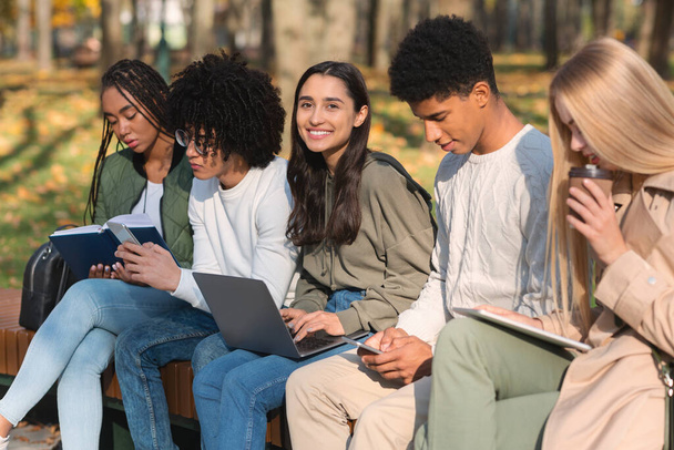 Teen-Freunde lernen im Freien, benutzen Geräte und lesen Bücher - Foto, Bild