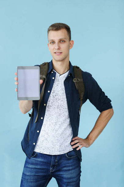 Handsome man with tablet on a blue background - Photo, image