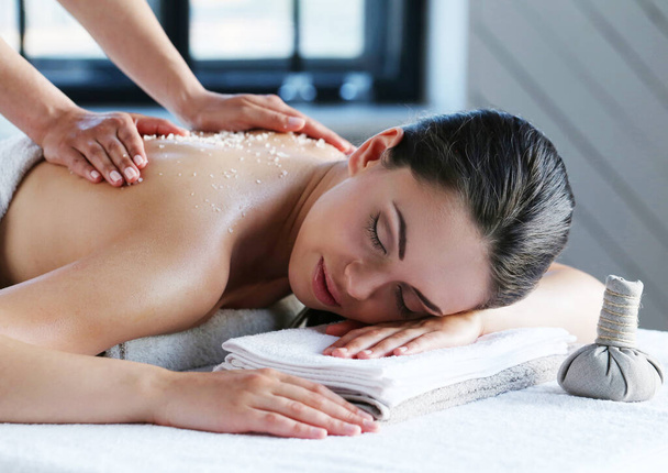 Jovem bela mulher relaxante durante a massagem no salão de spa
 - Foto, Imagem
