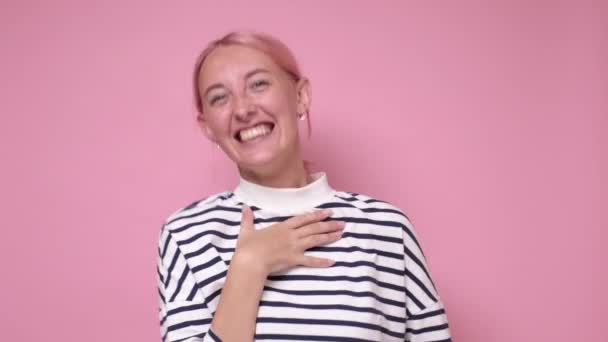Junge Kaukasierin mit gefärbten rosa Haaren lacht über lustigen Witz. - Filmmaterial, Video