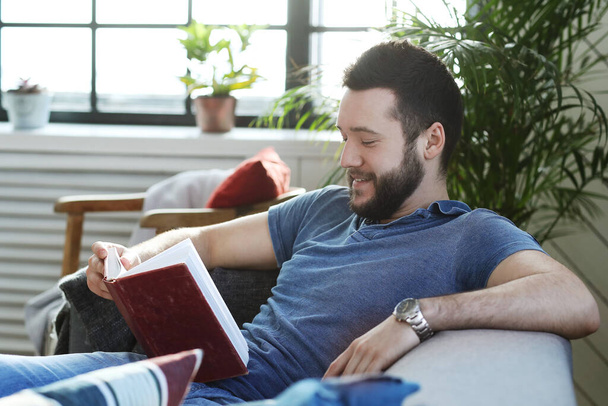 Hezký muž s vousy čtení knihy doma - Fotografie, Obrázek