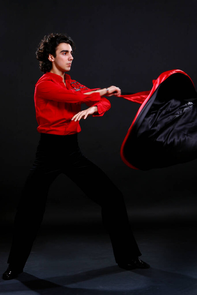young and attractive latino boy dancing on dark background - Valokuva, kuva