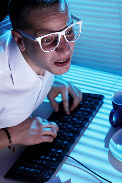 Divertido nerd en gafas navega por internet por la noche
 - Foto, imagen
